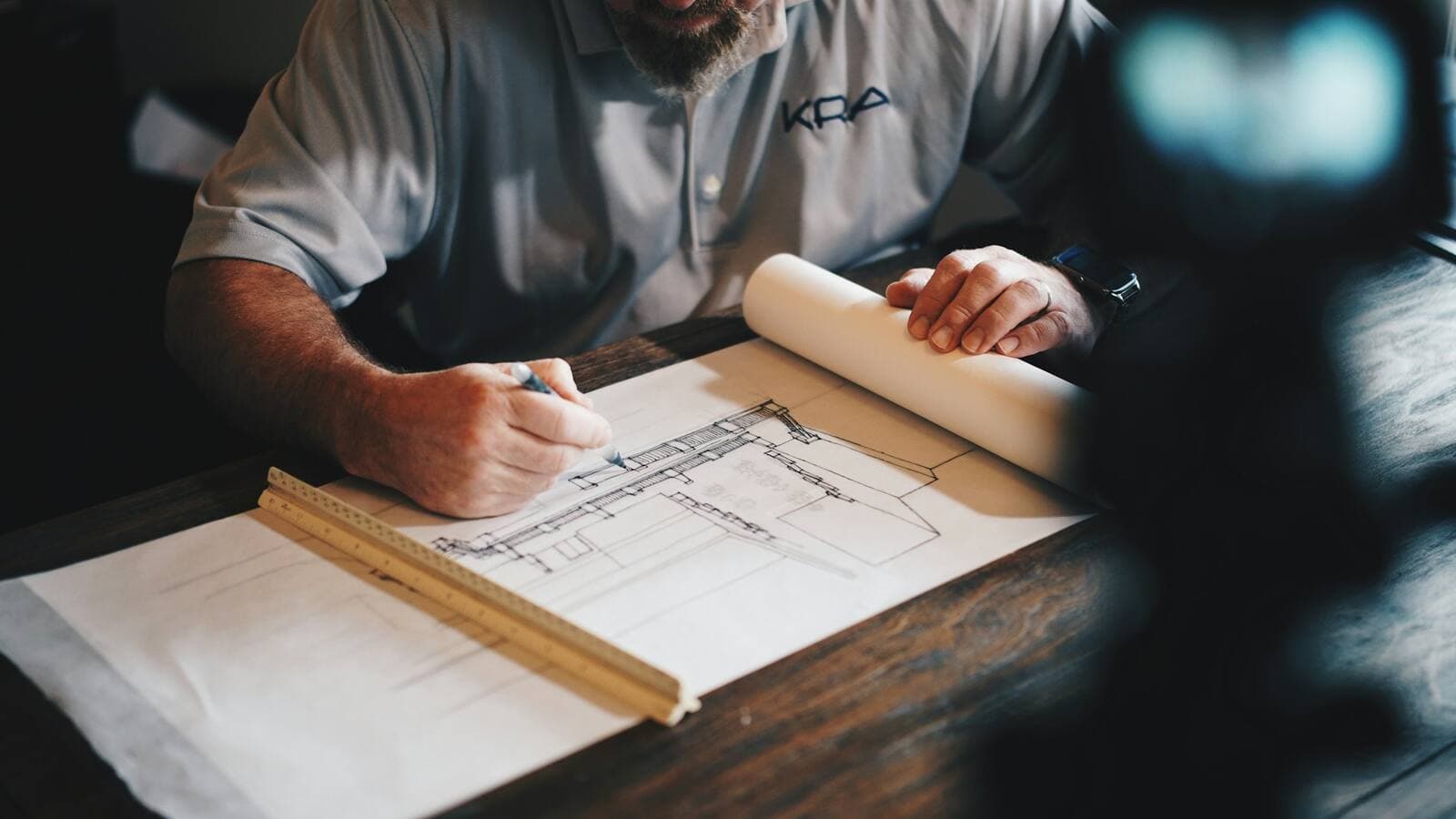 Hands marking up a set of construction drawings
