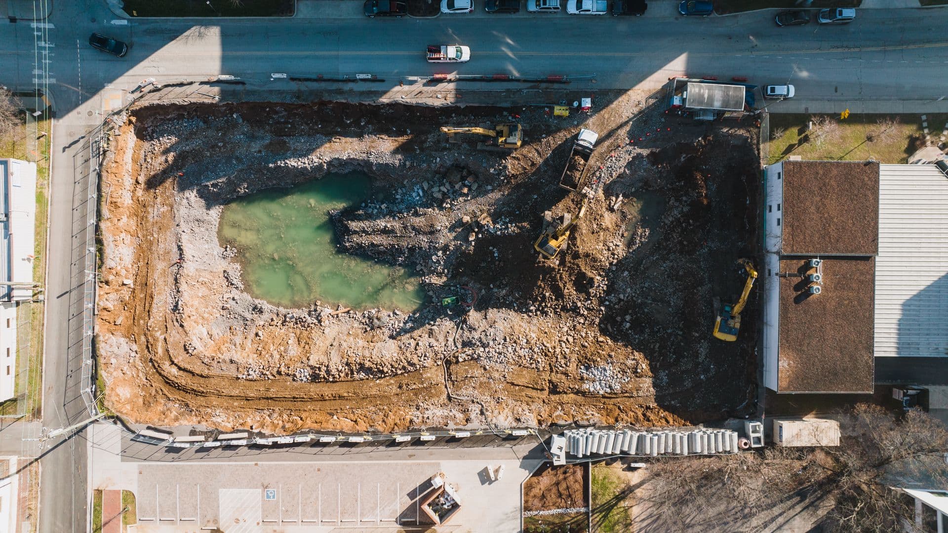 Drone view of a bulk excavation in progress with an excavator and haul road