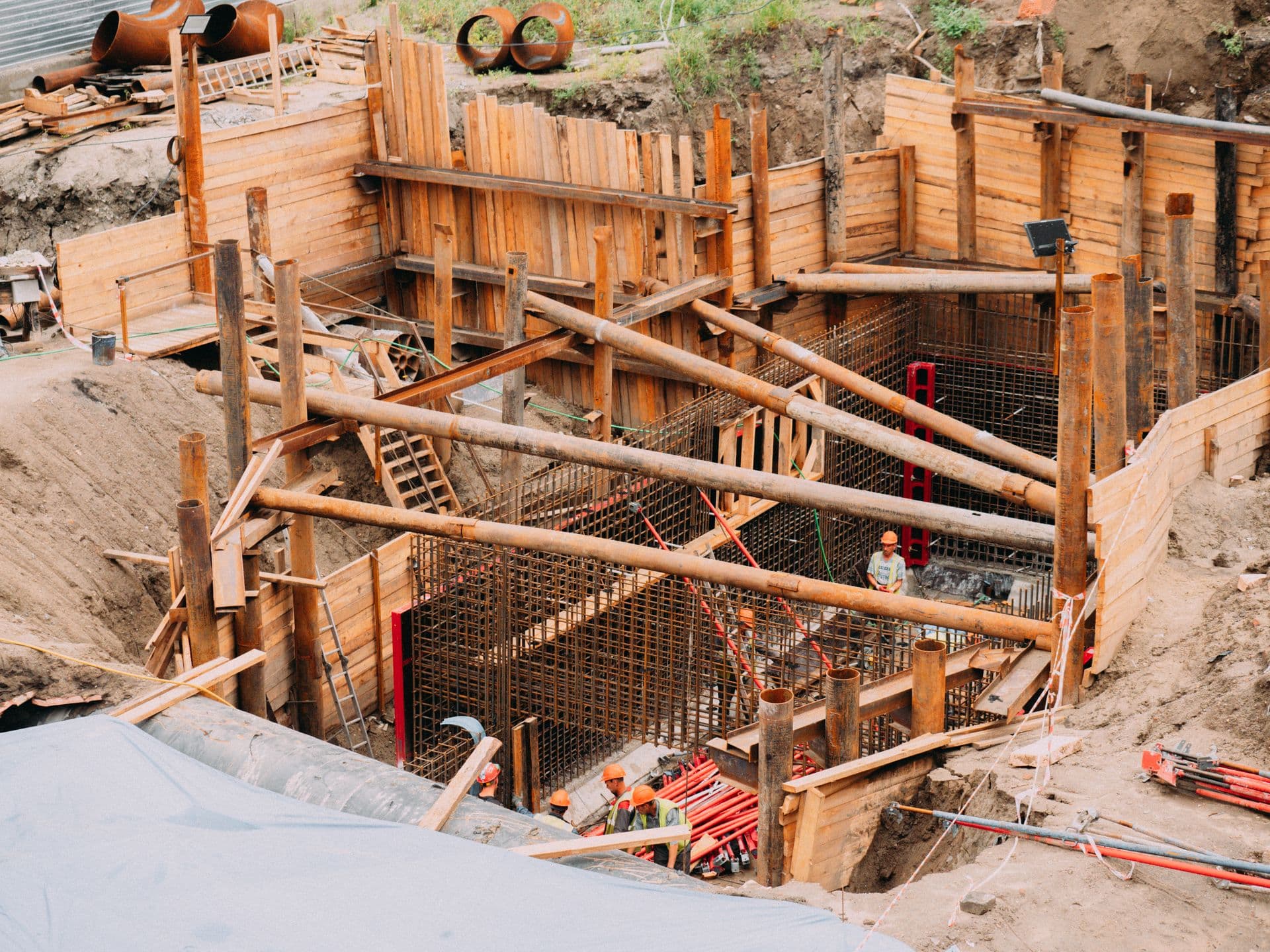Crew working on reinforcing steel for foundation walls in a shored excavation