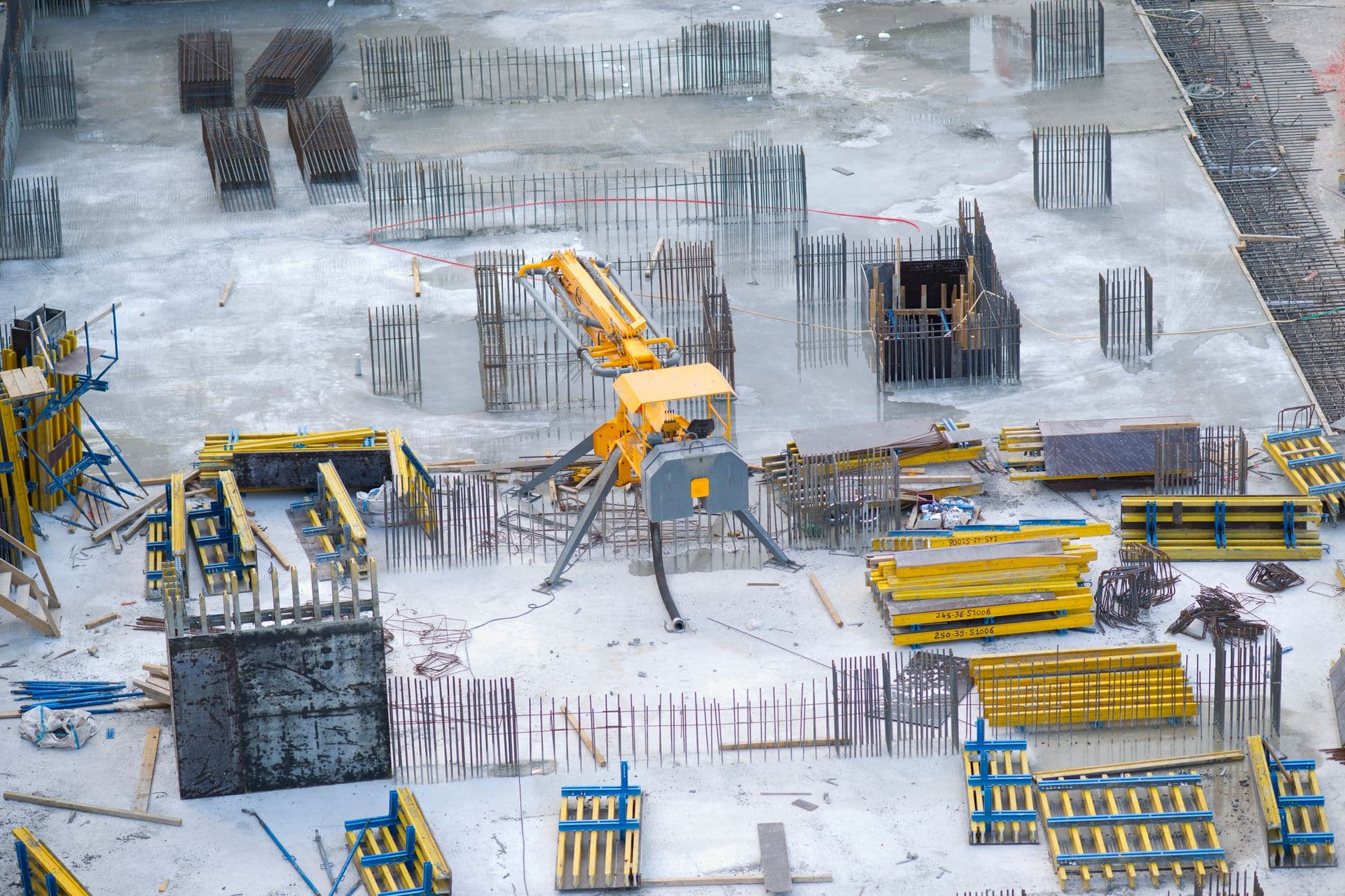 Overhead view of a concrete slab with column formwork and rebar on a construction site