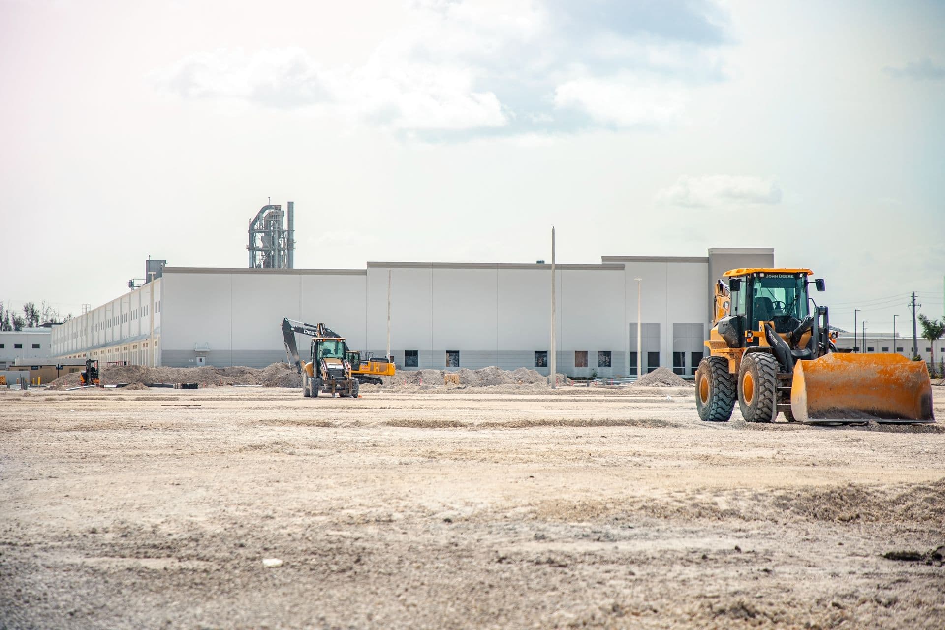 Warehouse building under construction with earthworks and machinery on site